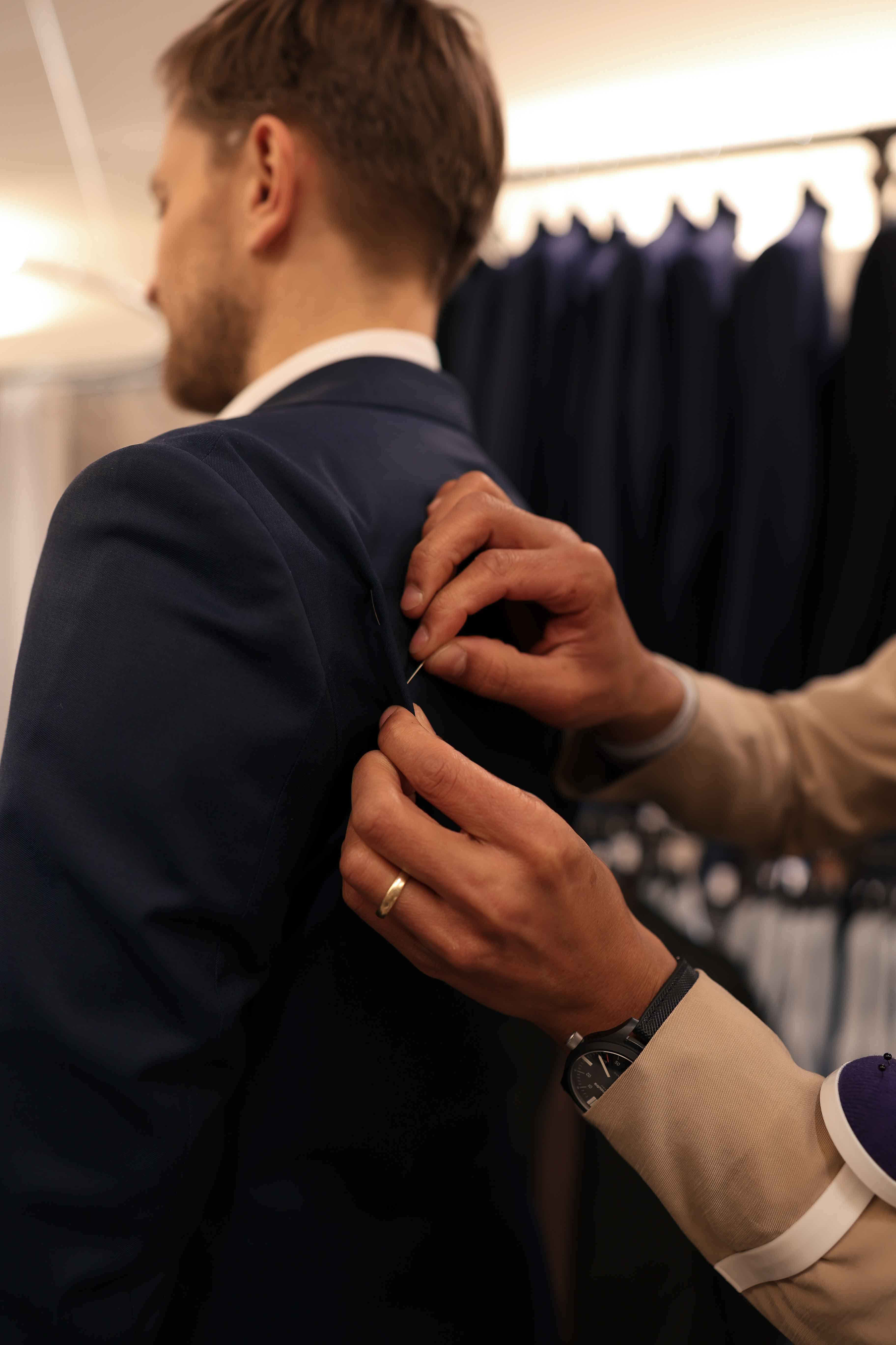 Kunde wird für seinen Hochzeitsanzug vermessen