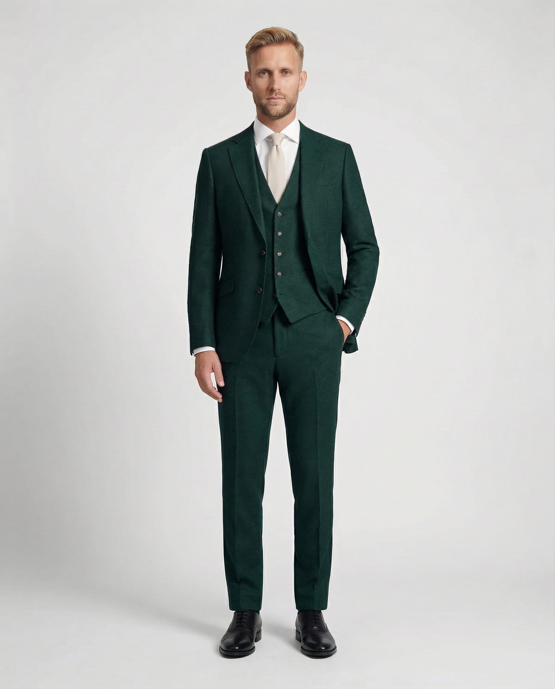 Mann im mittelgrünen Anzug mit Weste und Hand in der Tasche von vorne fotografiert