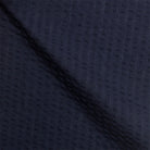 Detailaufnahme navy Seersucker-Stoff, charakteristische gekreppte Struktur, atmungsaktives Premium-Baumwollmaterial