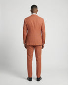 Mann im orangen Anzug von hinten fotografiert