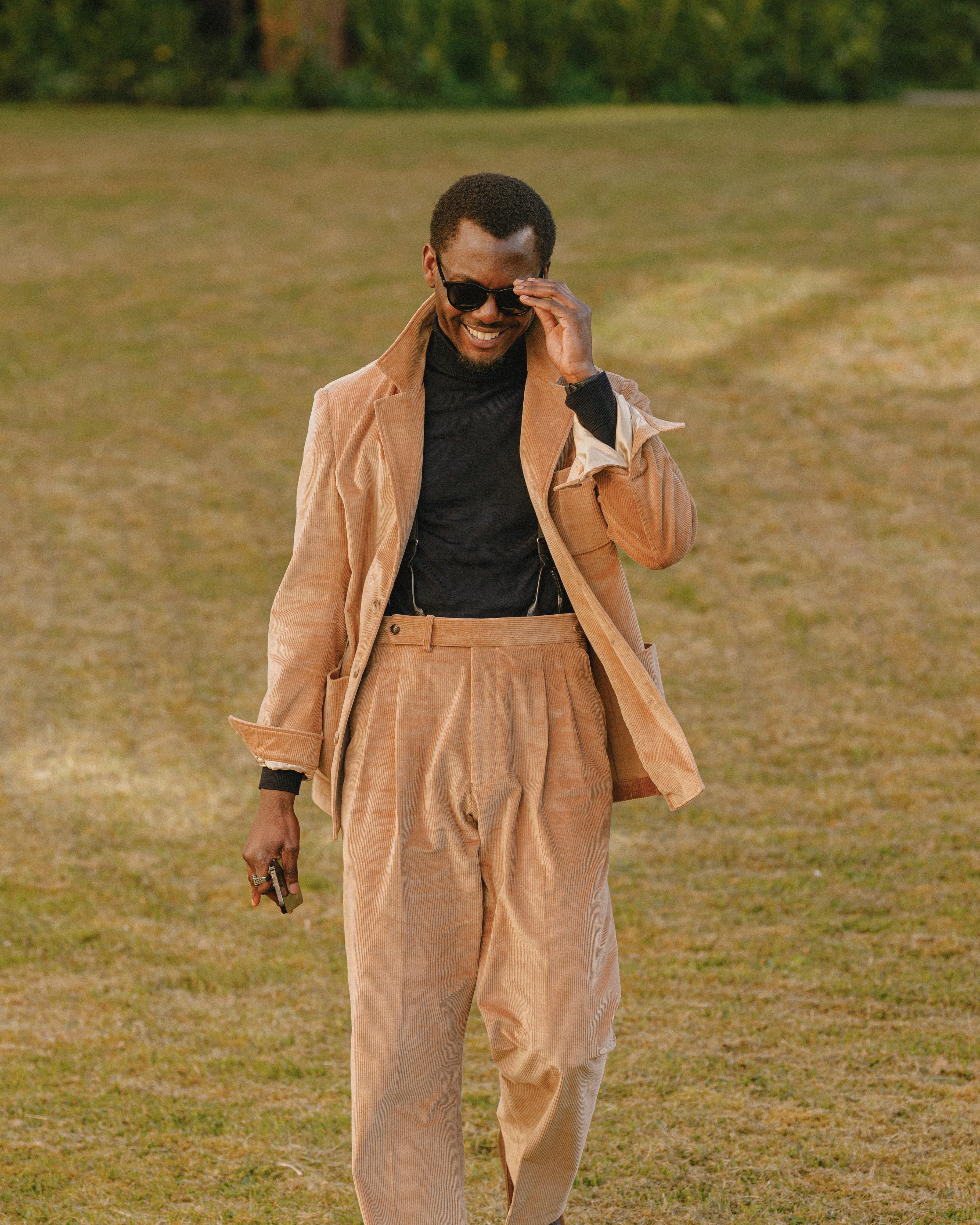 Junger Mann steht im Casual-Look auf einer Wiese