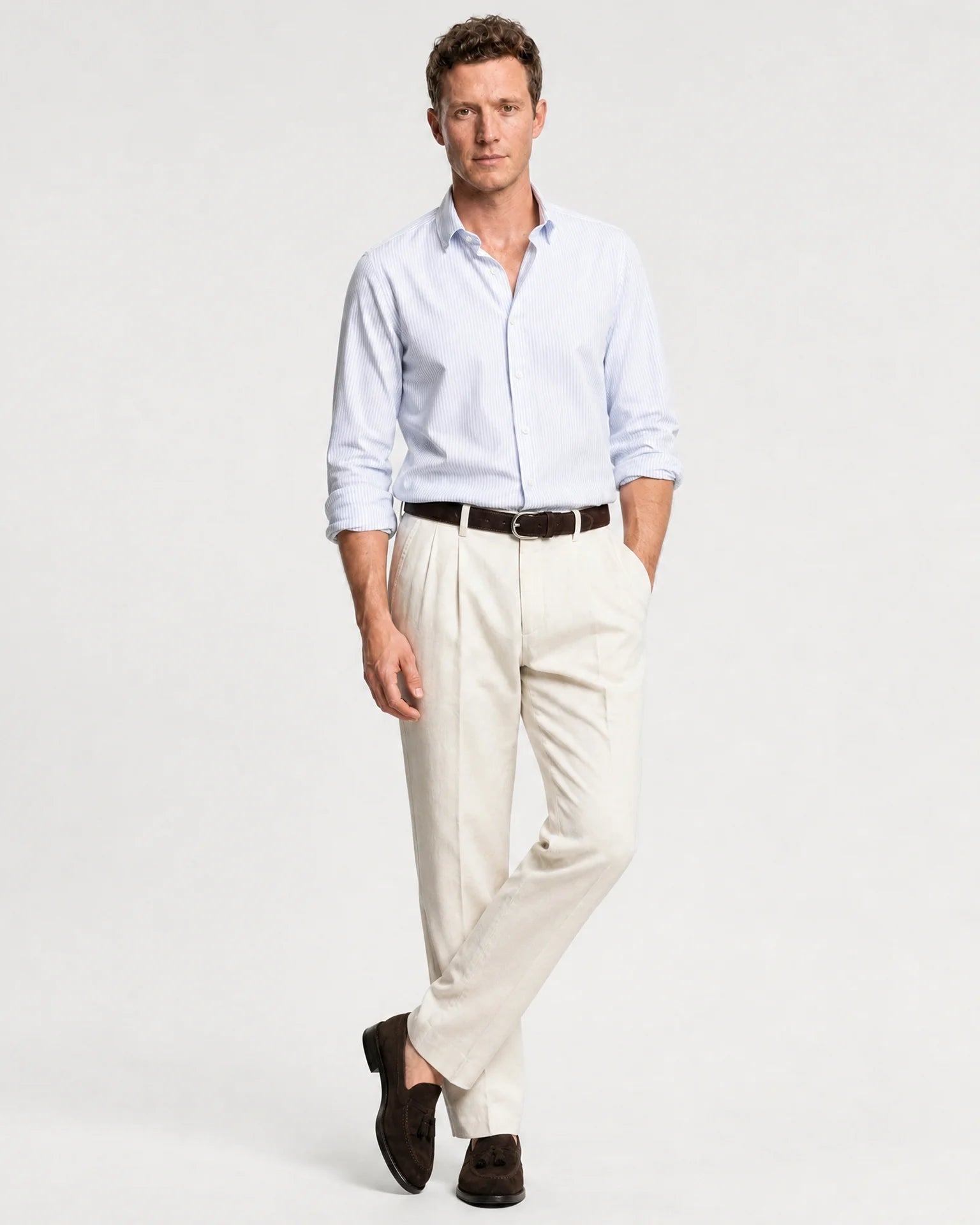 Herren Oxford-Hemd in Blau-Weiß gestreift kombiniert mit heller Hose, braunem Gürtel und Loafern.