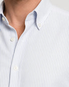 Detailaufnahme des blau-weiß gestreiften Oxford-Hemds mit Button-Down-Kragen und weißen Knöpfen.