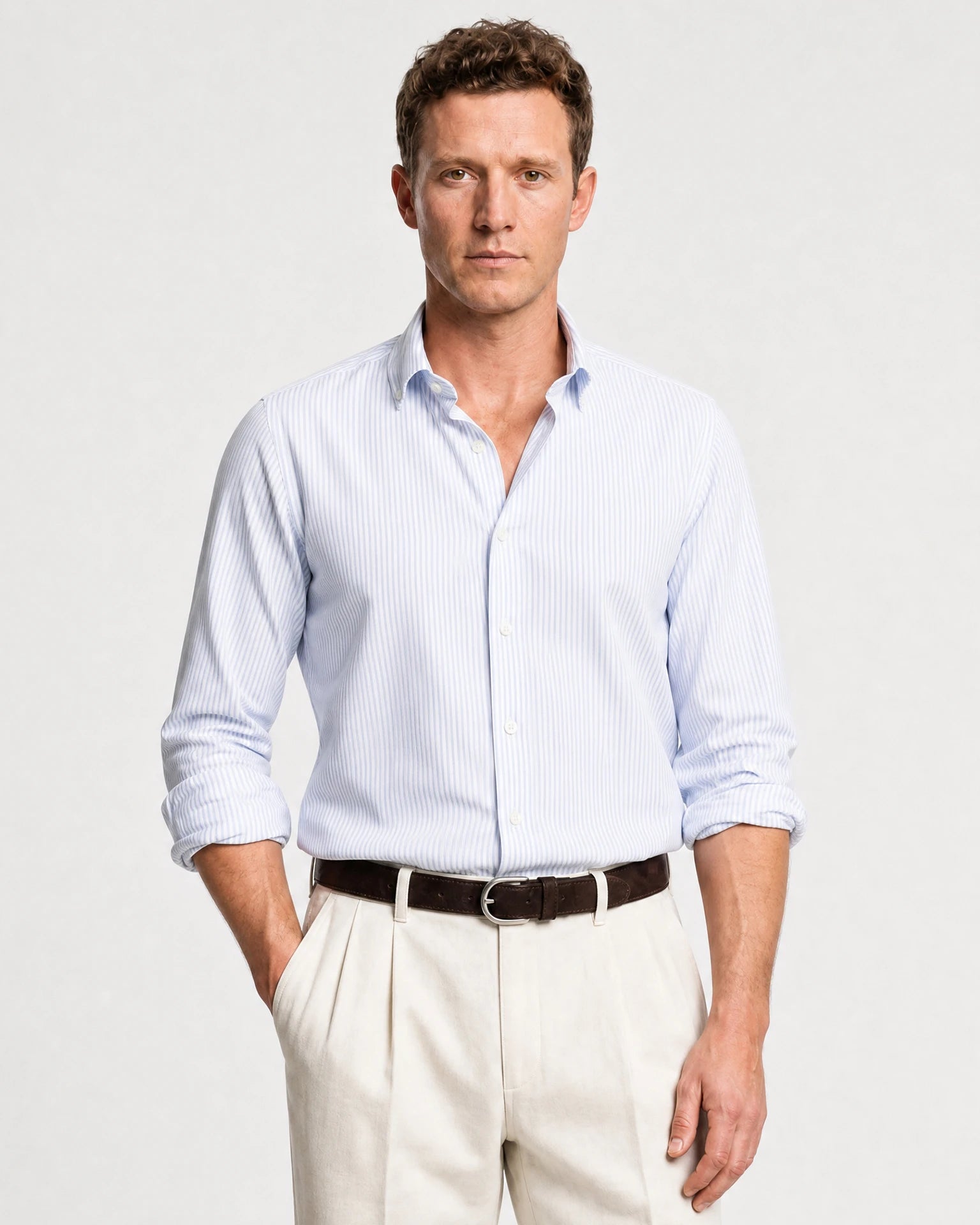 Blau-weiß gestreiftes Oxford-Hemd am Model mit offenem Kragen und hochgekrempelten Ärmeln.