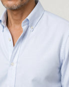 Detailaufnahme des hellblauen Oxford-Hemds mit Button-Down-Kragen, strukturierter Webung und weißen Knöpfen.