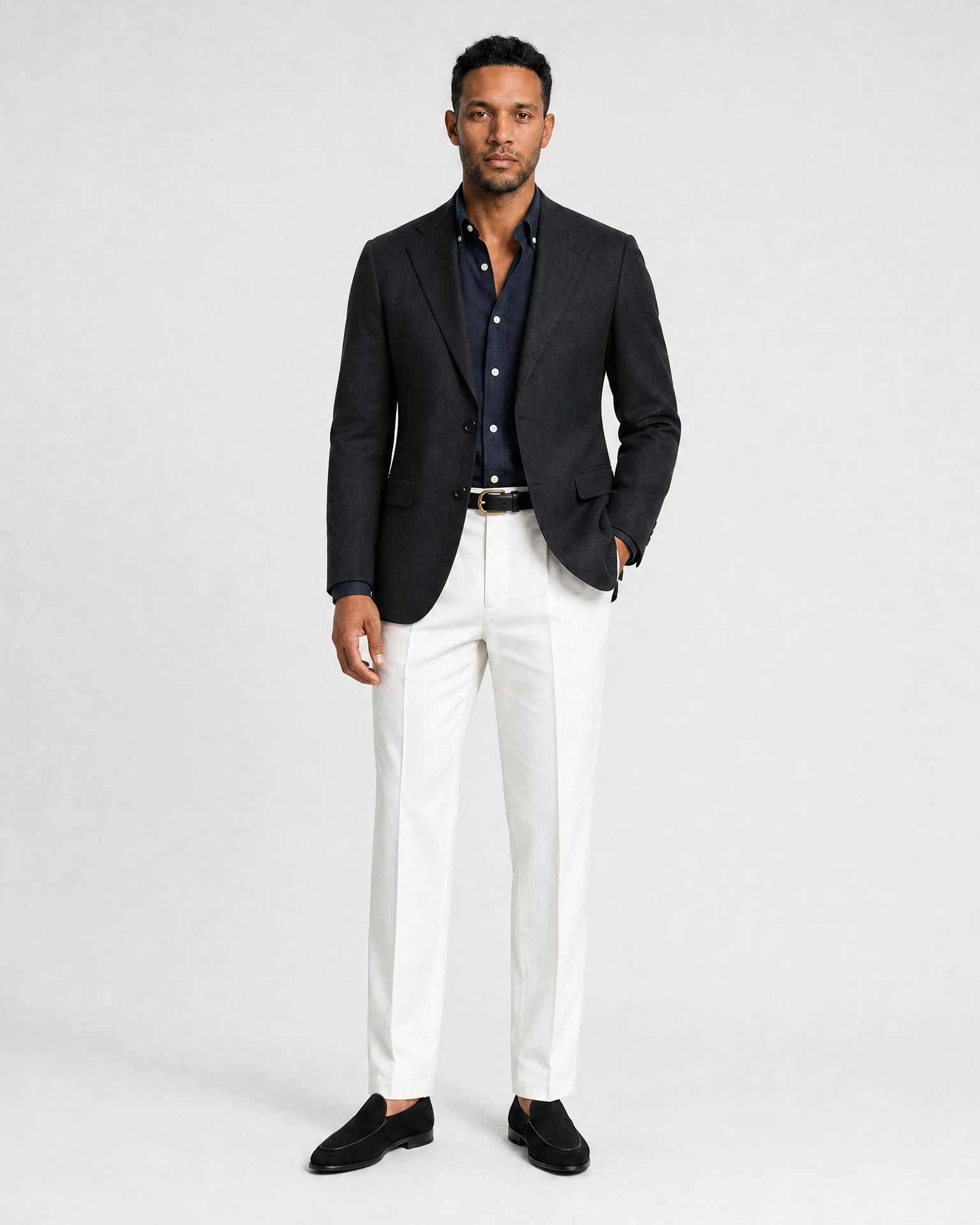 Dunkelblaues Navy Oxford-Hemd kombiniert mit dunklem Sakko, weißer Hose und schwarzen Loafern.