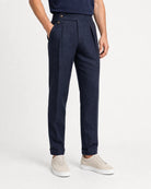 Frontansicht der navyblauen Leinenhose mit geradem Bein, Umschlag und hellen Sneakern.