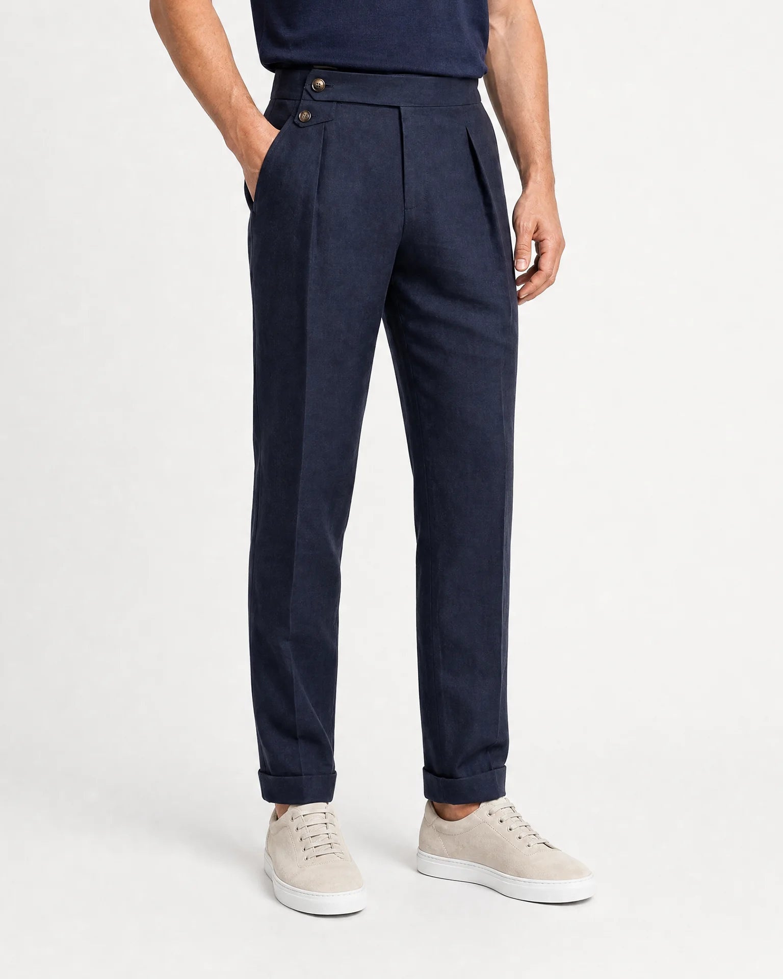 Frontansicht der navyblauen Leinenhose mit geradem Bein, Umschlag und hellen Sneakern.