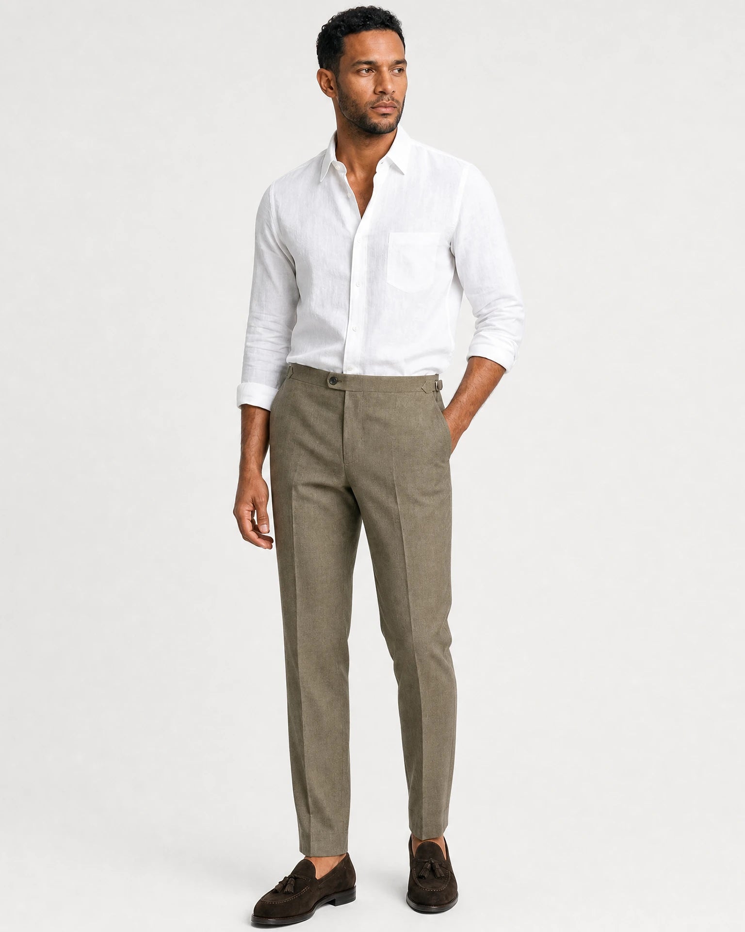 Ganzkörperansicht eines Models in olivgrüner Leinenhose mit weißem Hemd und dunkelbraunen Tassel-Loafern.