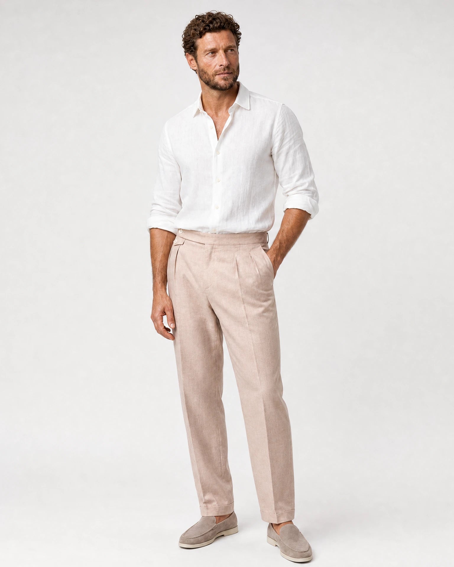 Ganzkörperansicht eines Models in puderfarbener Leinenhose aus hochwertigem Loro Piana Stoff, kombiniert mit weißem Leinenhemd.