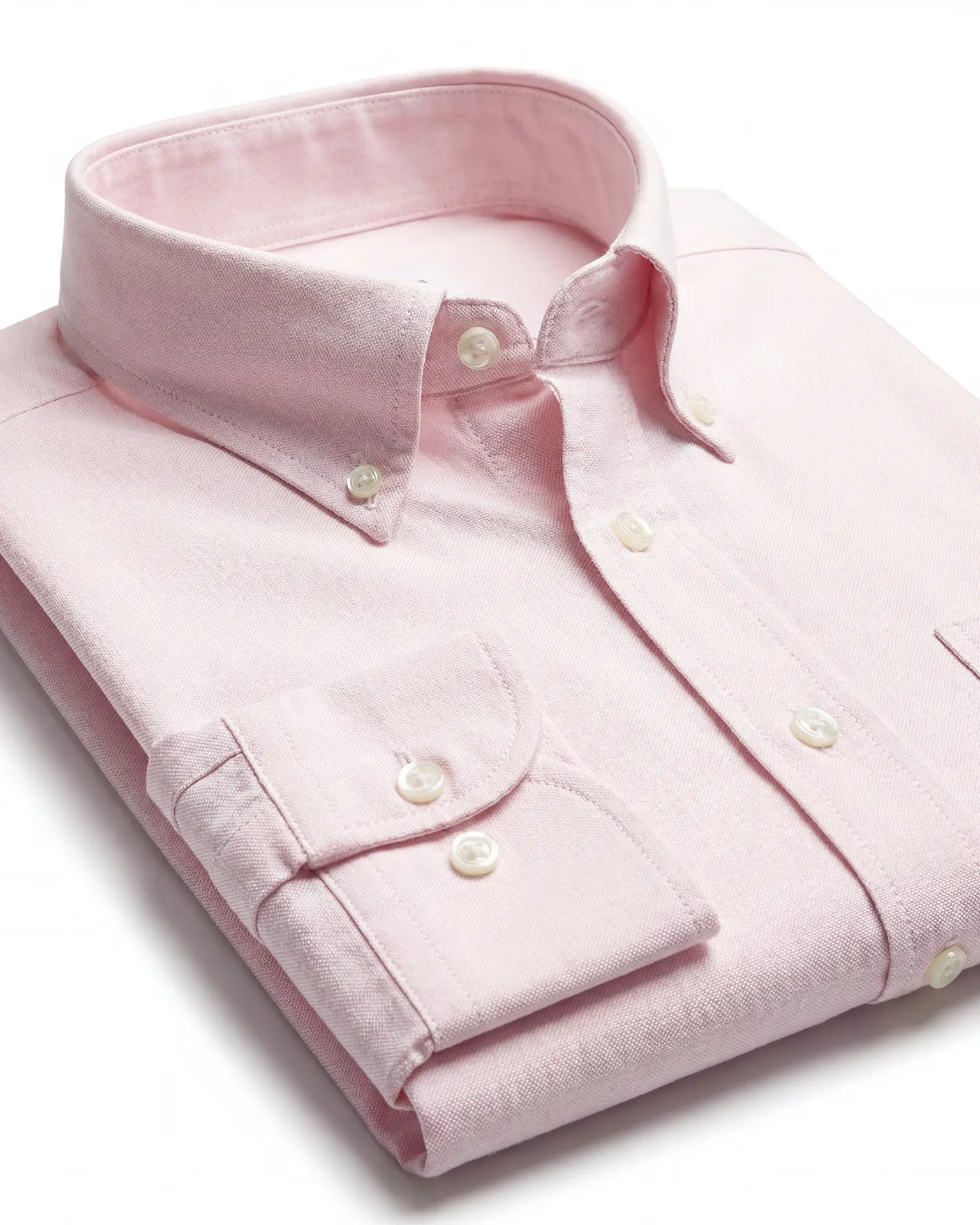 Detailaufnahme des roséfarbenen Oxford-Hemds mit Button-Down-Kragen, Manschette und weißen Knöpfen.