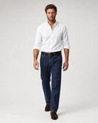 Frontansicht eines Models mit weißem Oxford-Hemd, dunkler Jeans und braunen Loafern.