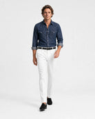 Mann trägt Rooks & Rocks Western Denim Hemd Dark Indigo mit weißer Hose und schwarzen Loafern, laufend