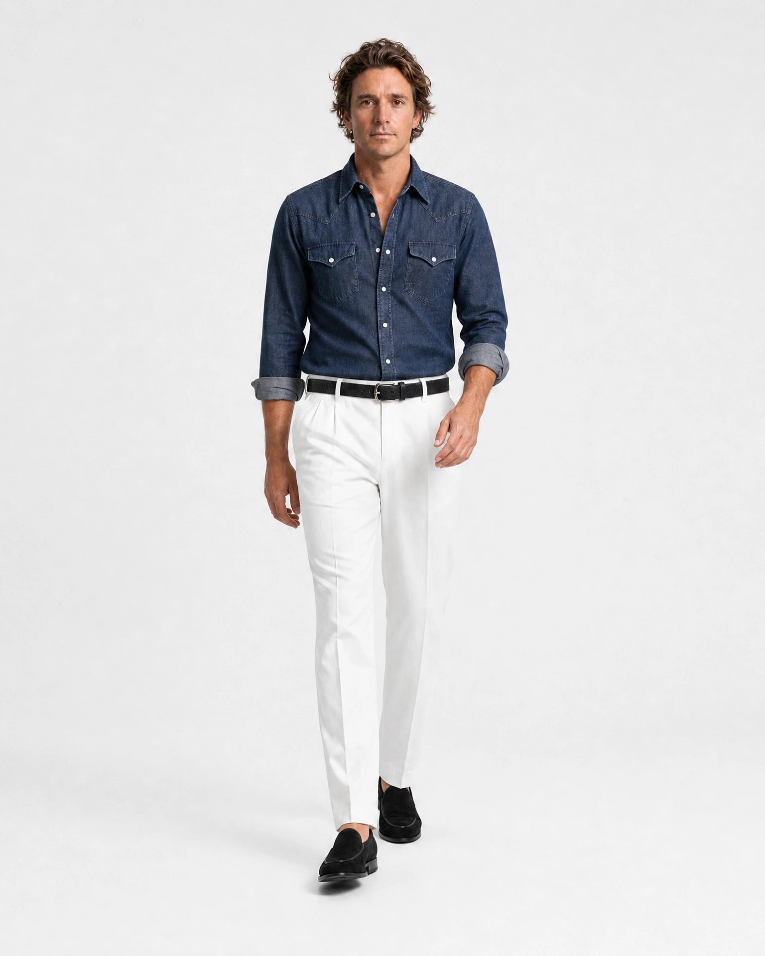 Mann trägt Rooks & Rocks Western Denim Hemd Dark Indigo mit weißer Hose und schwarzen Loafern, laufend
