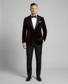 Mann im bordeauxfarbenen Samtsakko mit schwarzer Hose von vorne abgebildet mit Hand in der Tasche