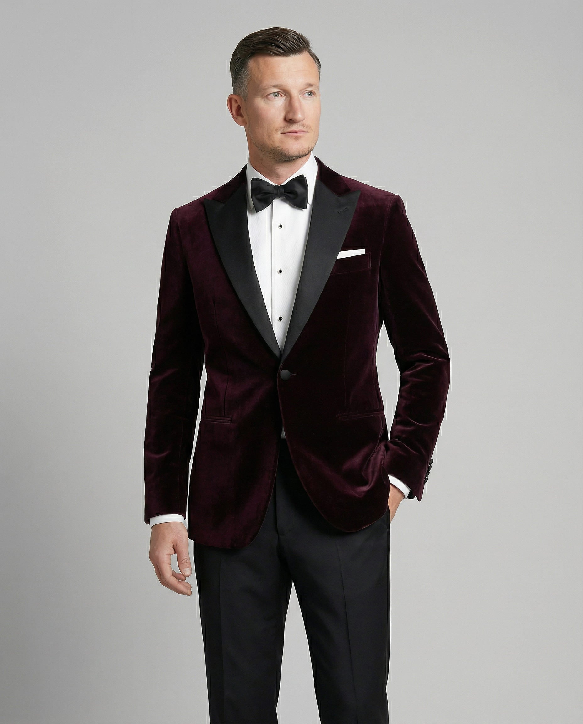 Mann im bordeauxfarbenen Samtsakko mit schwarzer Hose Nahaufnahme mit Hand in der Tasche