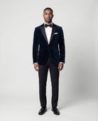 Mann im dunkelblauen Samtsakko mit schwarzer Hose von vorne abgebildet