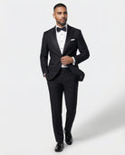 Mann im schwarzen Smoking in Bewegung mit Hand am Knopf von vorne gezeigt