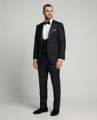 Mann im schwarzen Smoking mit offenem Sakko und Weste