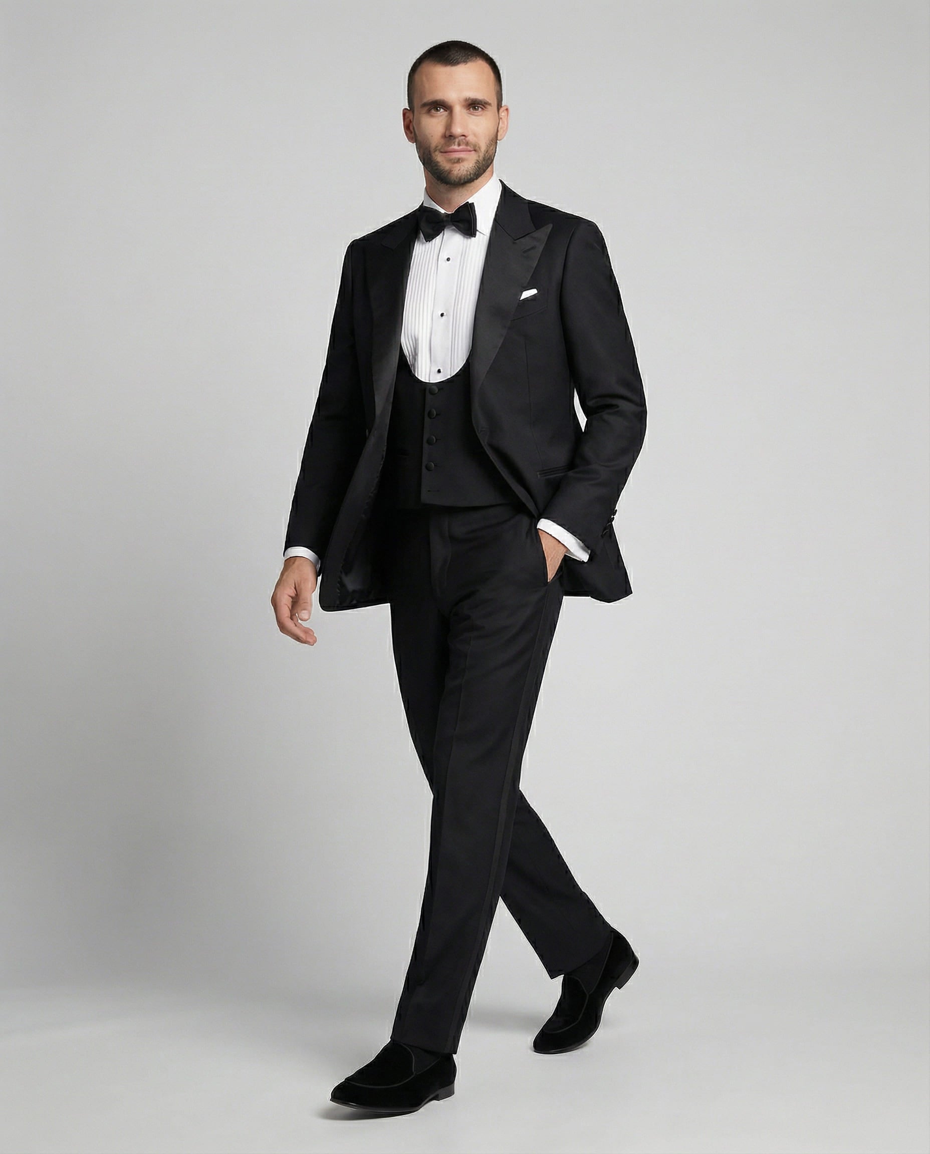 Mann im schwarzen Smoking mit Weste und Hand in der Tasche seitlich abgebildet