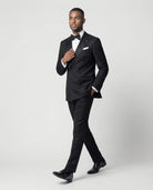 Mann im schwarzen zweireihigen Smoking in Bewegung mit Hand in der Tasche