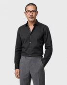 Schwarzes Maßhemd Herren Oberkörper, offener Haifischkragen, zu grauer Bundfaltenhose, eleganter Business-Look