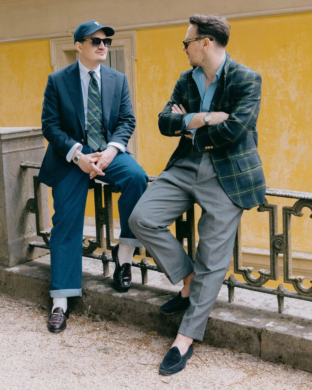 Sommerliches Casual Tailoring für Herren mit Sakko, Hemd, Krawatte und lockerer Stoffhose vor mediterraner Fassade