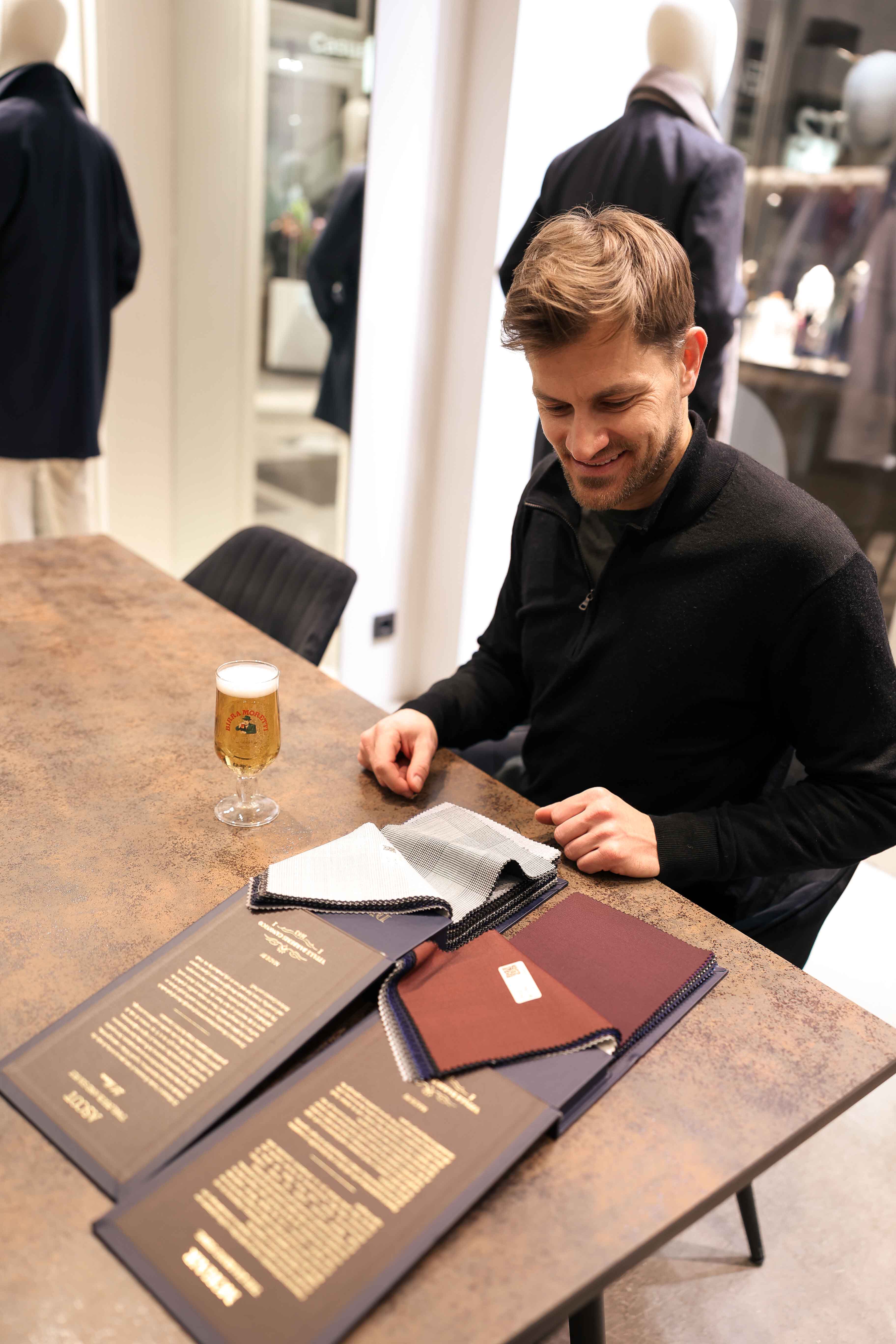 Kunde wählt sich den passenden Stoff für seinen Hochzeitsanzug aus