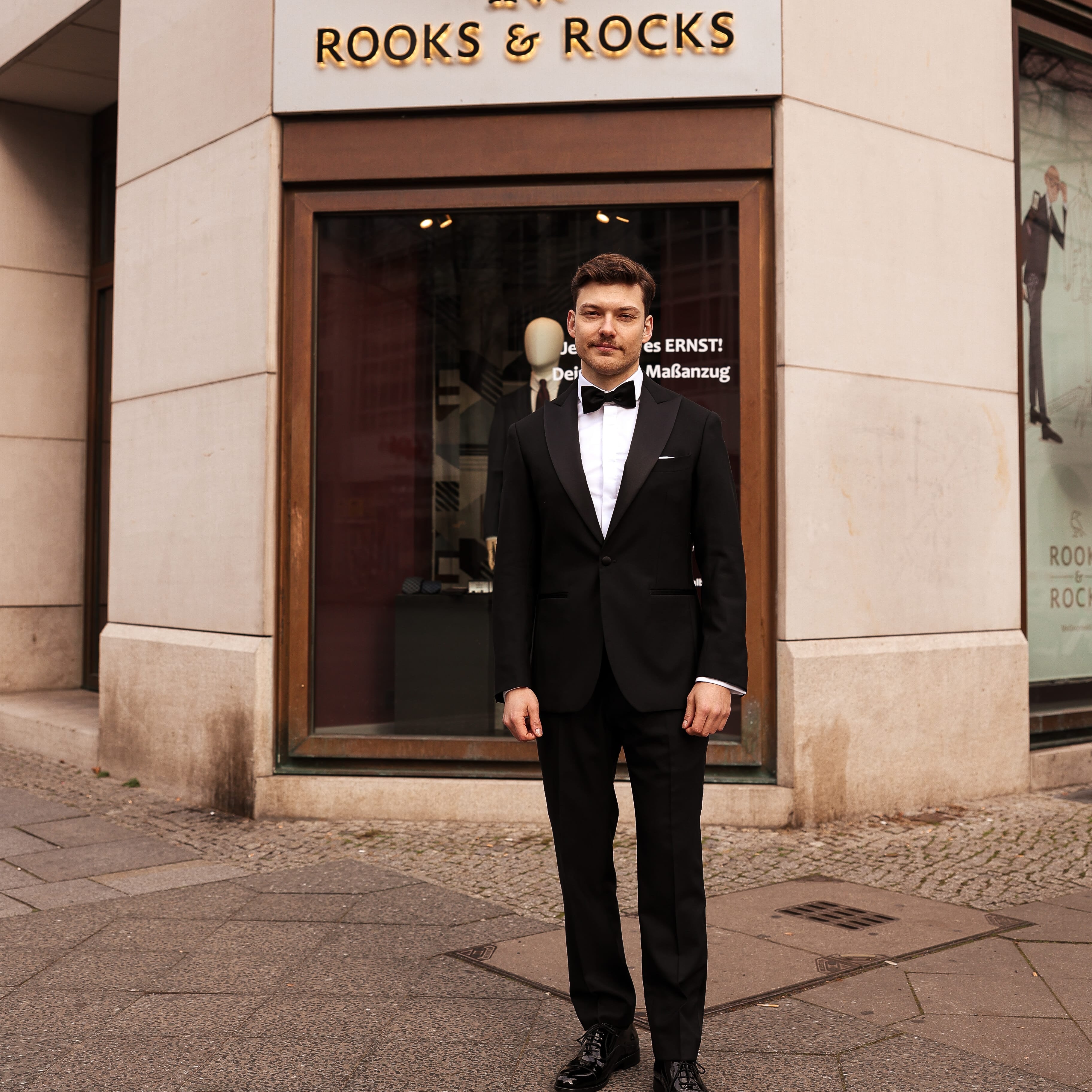 Kunde Lion im schwarzen Smoking vor der Rooks & Rocks Filiale in Berlin