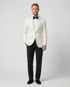 Mann im weißes Dinnerjacket mit schwarzer Hose von vorne gezeigt mit Hand in der Tasche