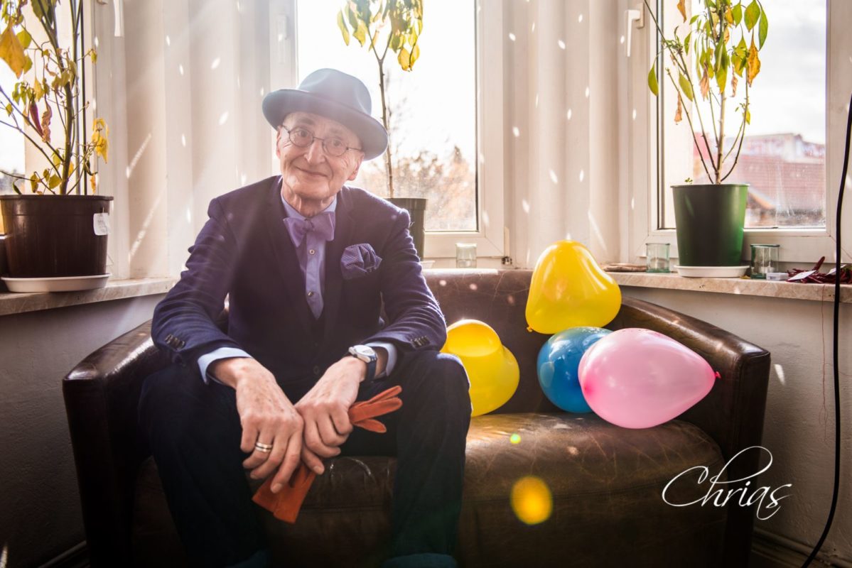 Günther Krabbenhöft sitzt auf einer Couch voller Luftballoons